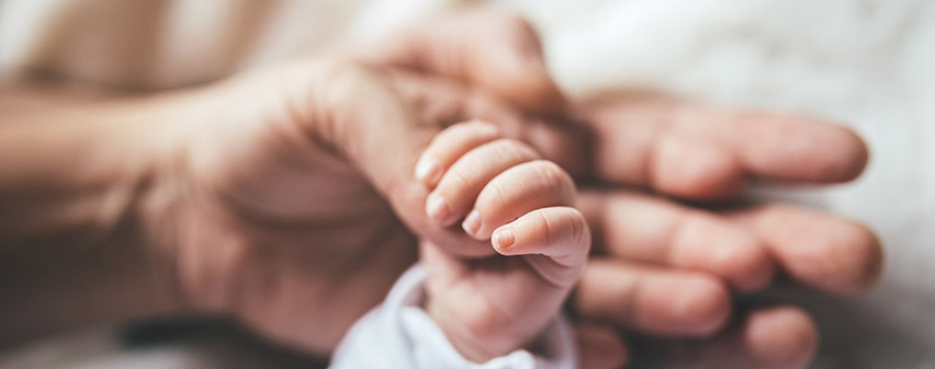 Mom holding newborn's hand